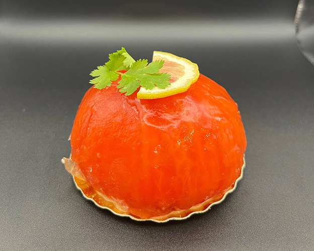 Gâteau rouge vif en forme de dôme, garni de coriandre et d'un quartier de citron à Saint-Germain-en-Laye dans les Yvelines 78