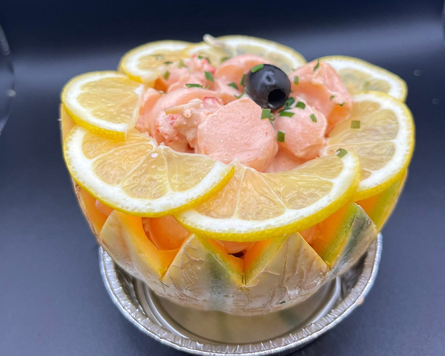 Salade de fruits de mer et tranches de citron dans un bol sculpté de melon à Saint-Germain-en-Laye dans les Yvelines 78