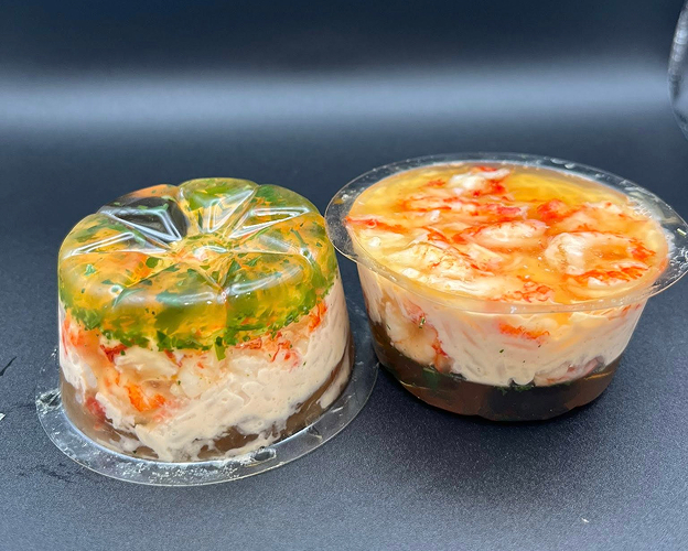 Deux aspics de fruits de mer en gelée, l'un renversé, sur fond noir à Saint-Germain-en-Laye dans les Yvelines 78