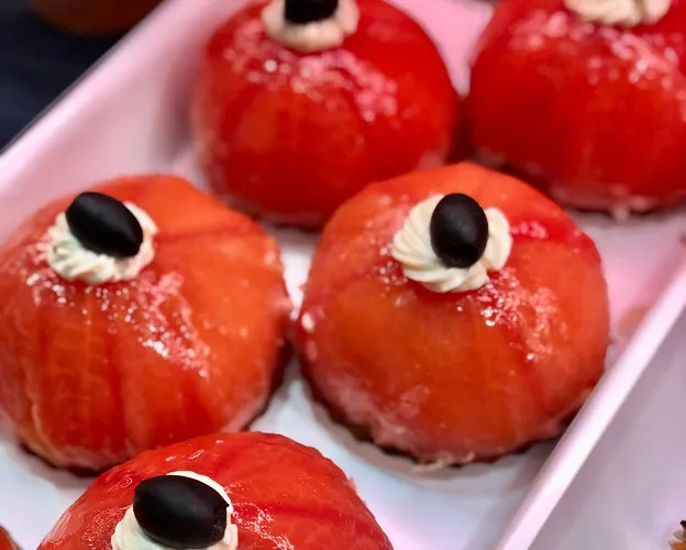 Desserts rouges ronds glacés avec une garniture crème et olive noire à Saint-Germain-en-Laye dans les Yvelines 78