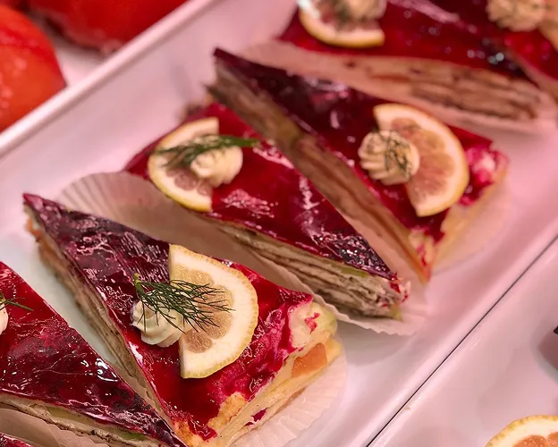 Tranches de gâteau salé avec glaçage rouge, citron, crème et aneth sur plateau blanc à Saint-Germain-en-Laye dans les Yvelines 78